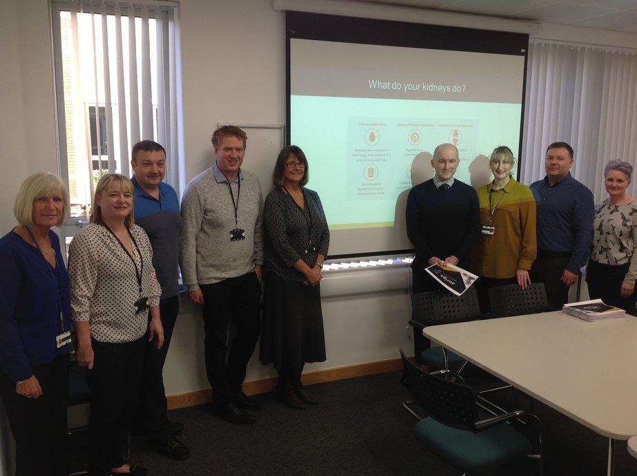 WPD staff standing in front of power point presentation