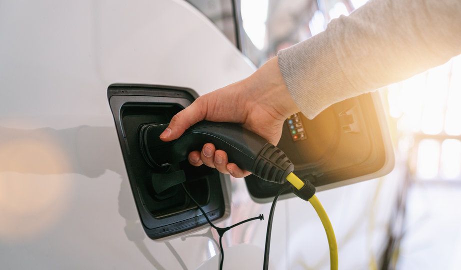 An electric car charger being plugged in to a car