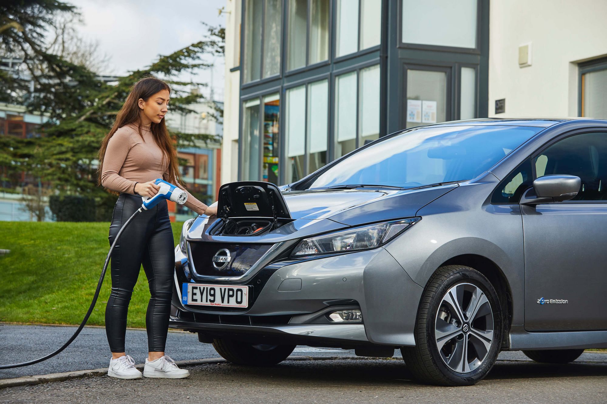 woman charging electric vehicle (EV)