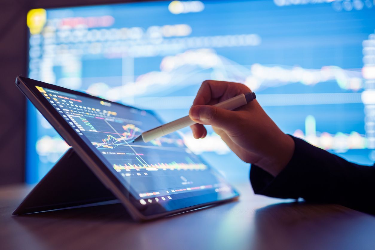 Hand with stylus pointing to data on a tablet screen