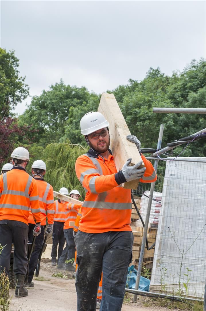 WPD apprentice worker carrying plank of wood