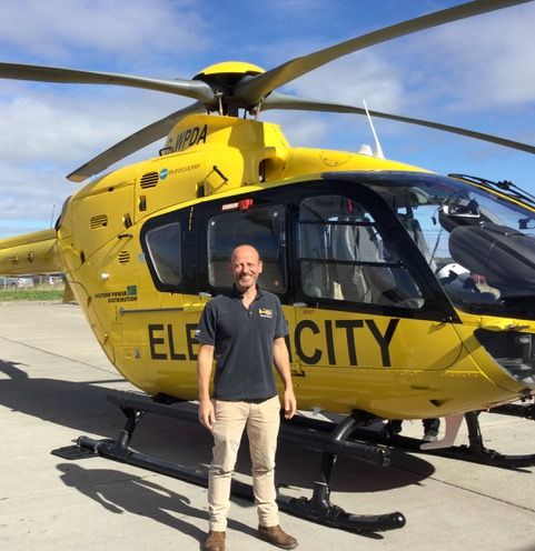 WPD employee standing in front of a helicopter