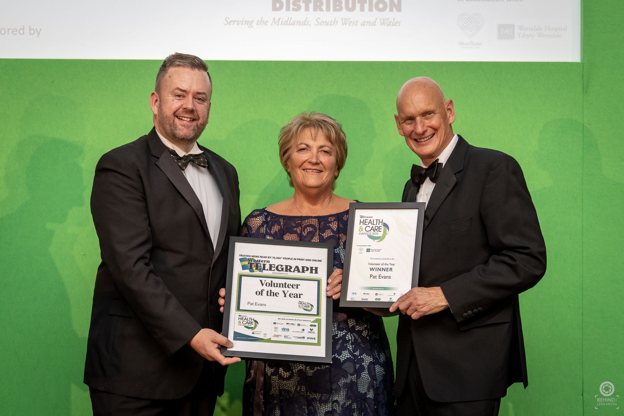 Three people holding an award