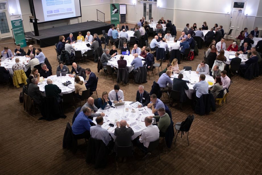 Colleagues sitting at round tables in a room