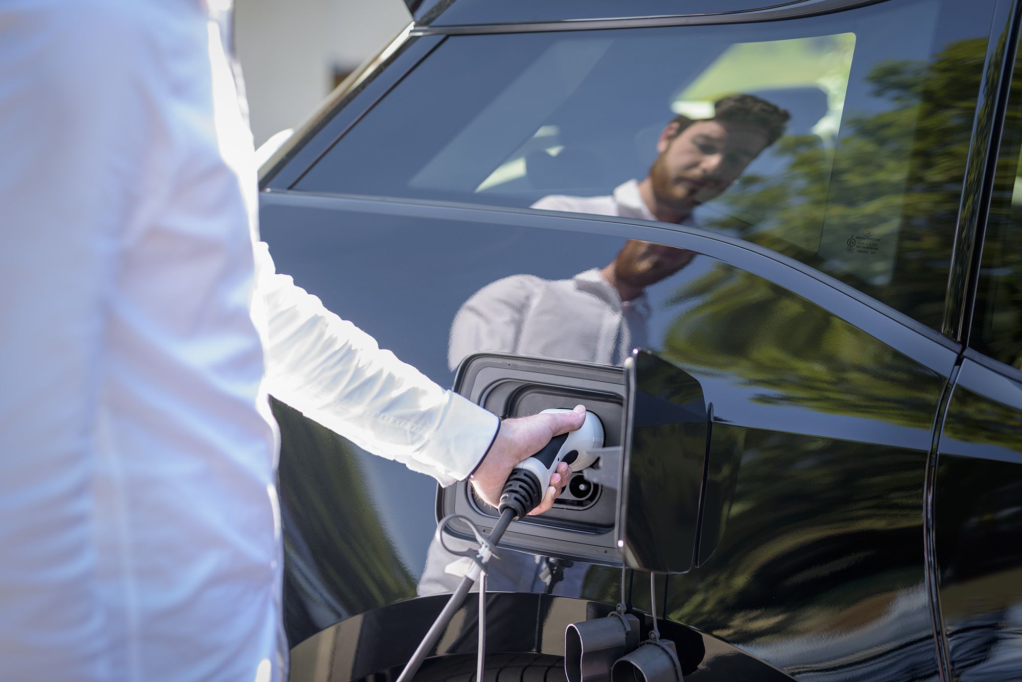 Electric car being plugged in to charge